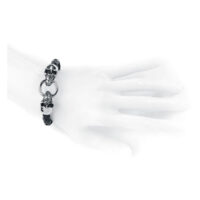 Bracelet en cuir noir avec détails de tête de mort Bracelet en cuir noir avec têtes de mort argentées sur un modèle de main blanche