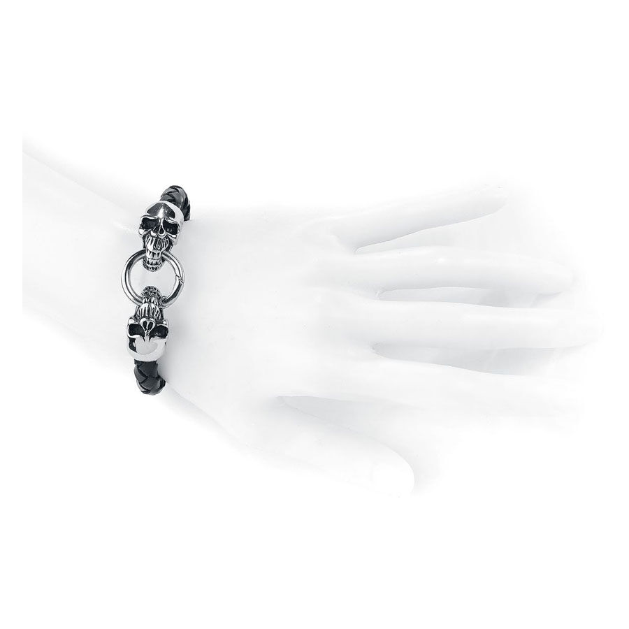 Bracelet en cuir noir avec détails de tête de mort Bracelet en cuir noir avec têtes de mort argentées sur un modèle de main blanche
