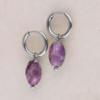 Créoles argentées avec pendentif améthyste Deux créoles argentées avec pendentif améthyste violet sur fond beige