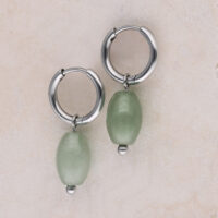 Créoles en acier inoxydable avec aventurine verte Deux créoles argentées avec pendentifs en aventurine verte sur fond clair