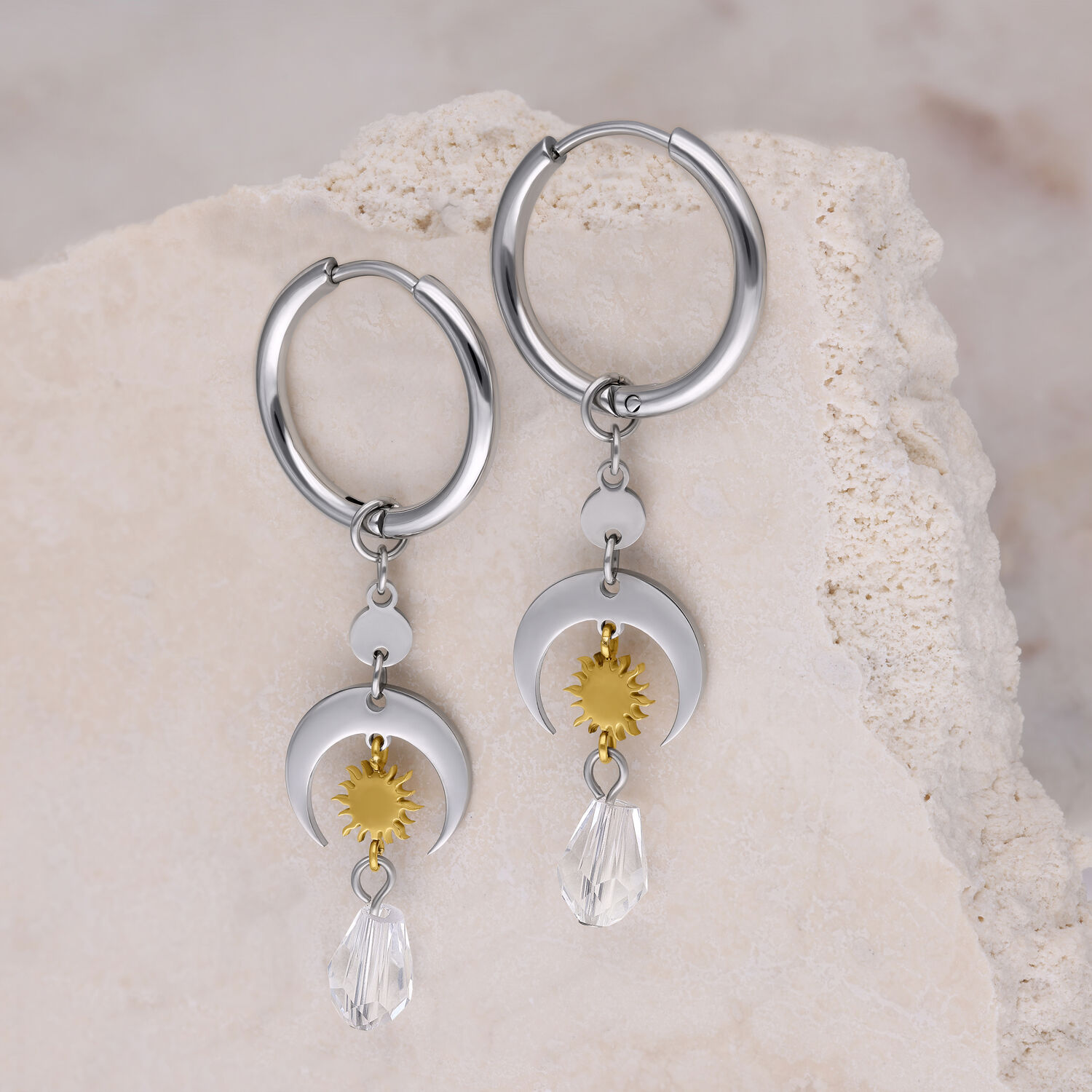 Créoles argentées avec soleils dorés et cristaux Créoles argentées avec pendentifs soleils dorés et cristaux clairs sur fond clair