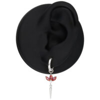 Boucle d'oreille argentée avec cristaux rouges sur un modèle d'oreille noir