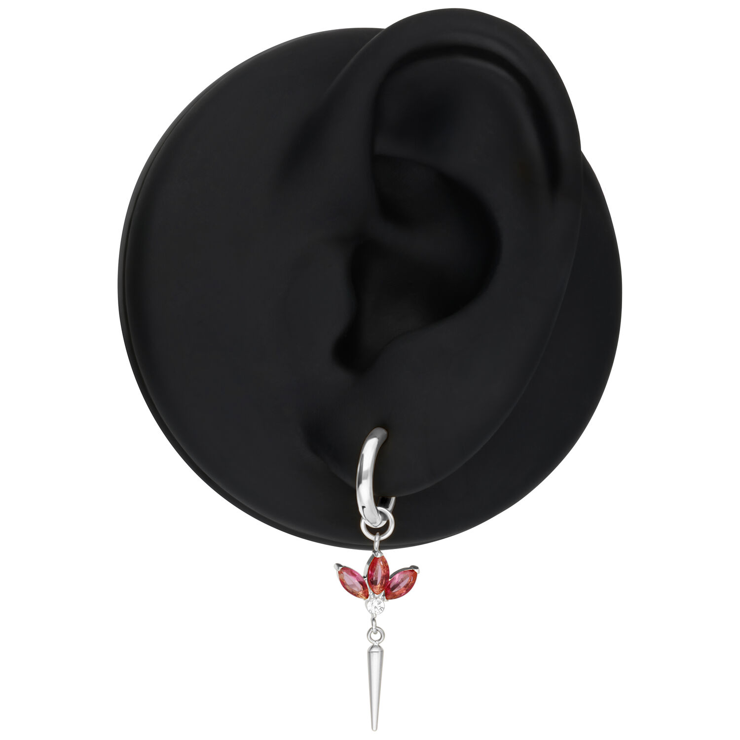 Boucle d'oreille argentée avec cristaux rouges sur un modèle d'oreille noir