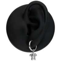 Boucles d'oreilles argentées avec pendentif tortue Boucle d'oreille argentée avec pendentif tortue sur un modèle d'oreille noire