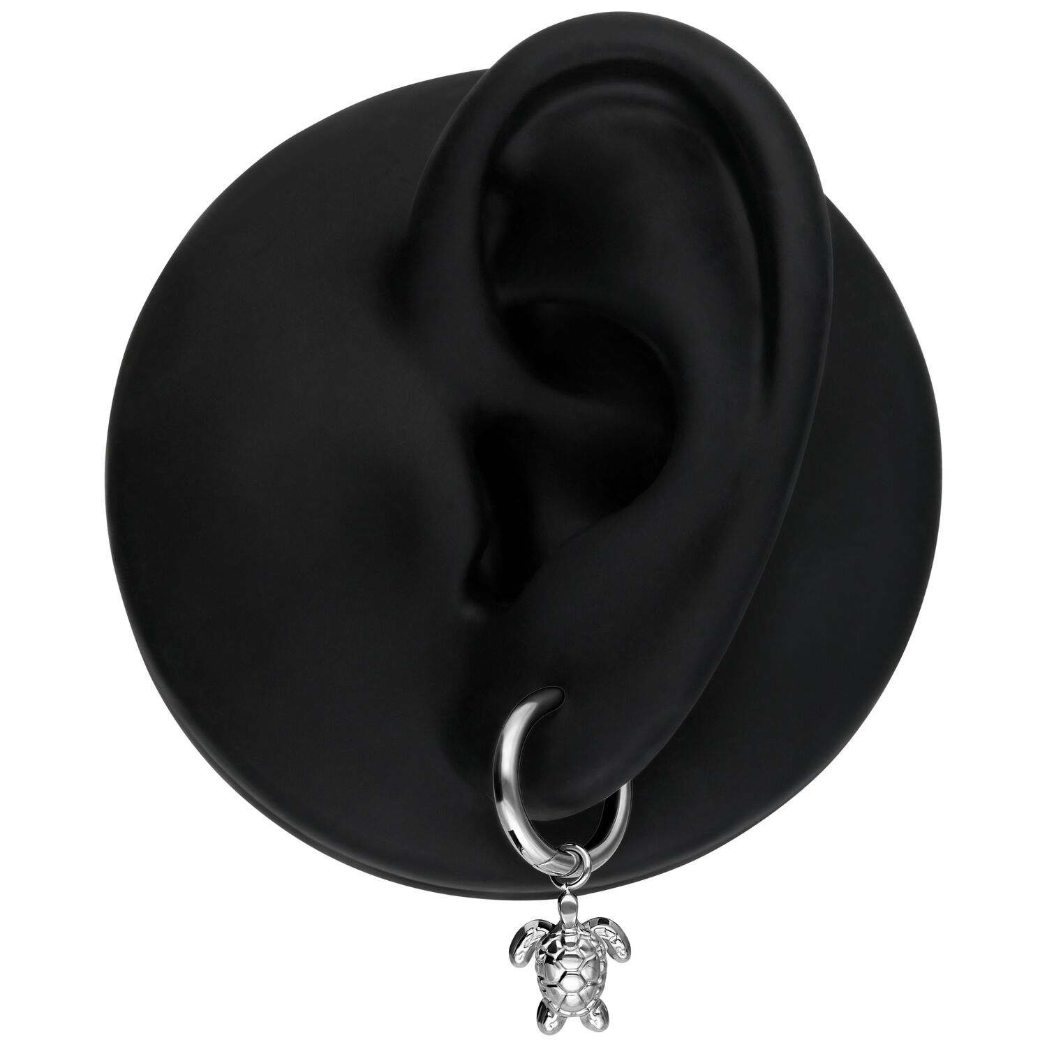 Boucles d'oreilles argentées avec pendentif tortue Boucle d'oreille argentée avec pendentif tortue sur un modèle d'oreille noire