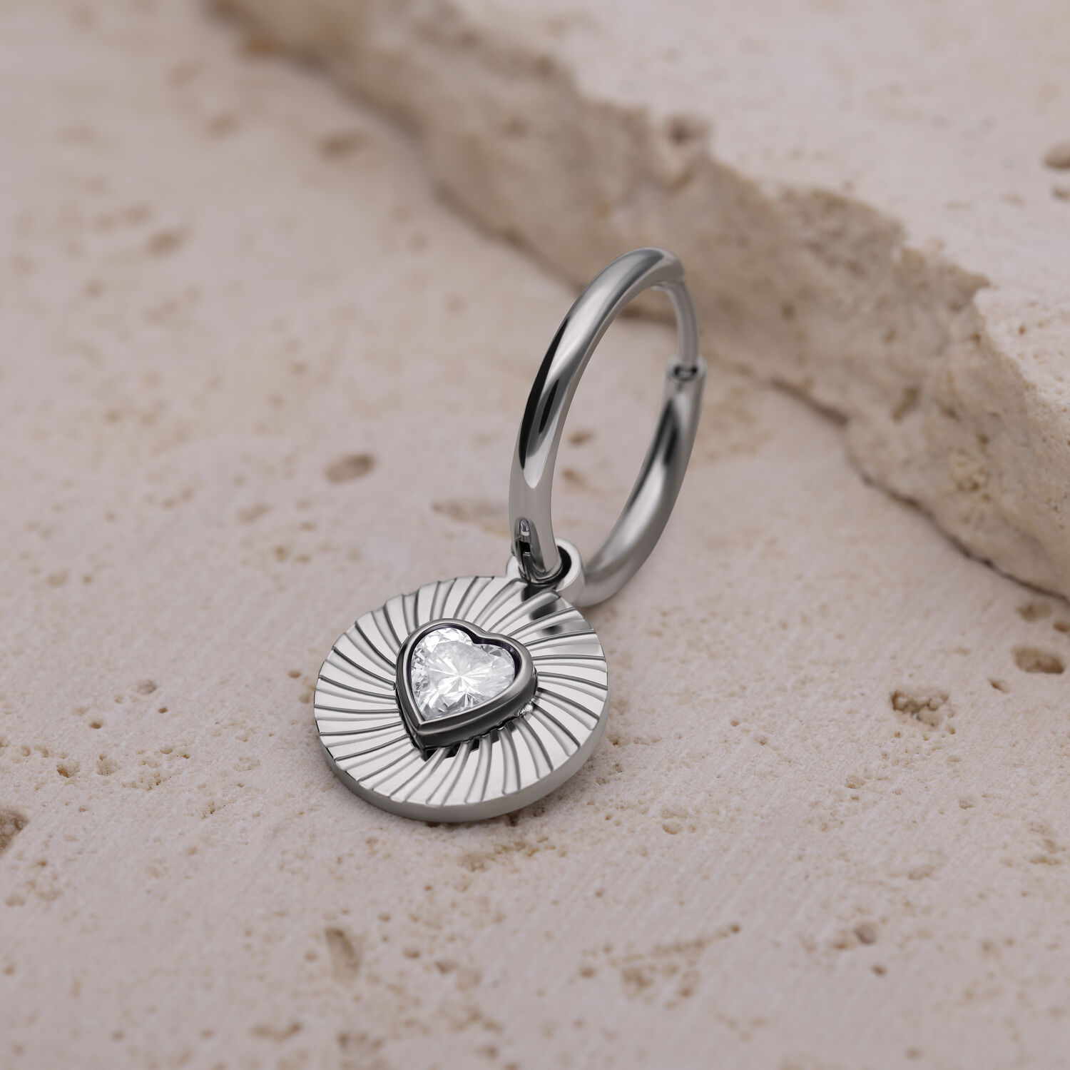 Boucles d'oreilles argentées avec pendentif cœur Boucle d'oreille argentée avec pendentif en forme de cœur sur pierre claire