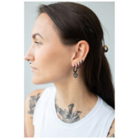 Femme avec des boucles d'oreilles Little Skull Hoops noires en acier chirurgical