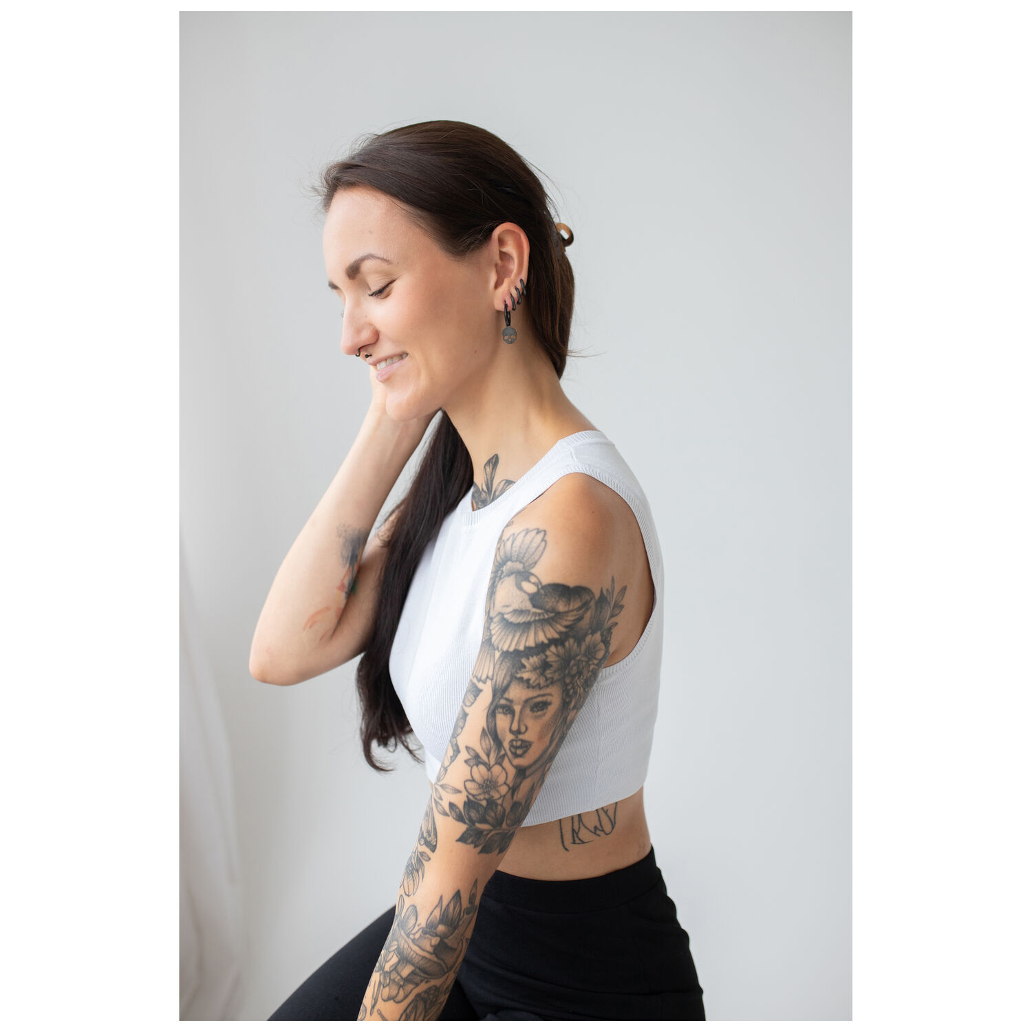 Femme aux cheveux longs portant des boucles d'oreilles crâne noires sur fond clair