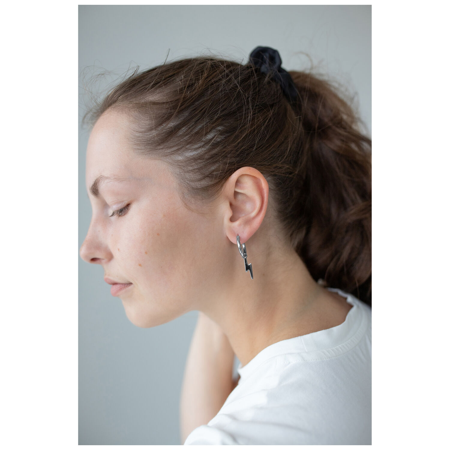 Boucles d'oreilles Little Flash Hoops stylées Femme avec une tresse noire portant des boucles d'oreilles Little Flash Hoops en acier chirurgical