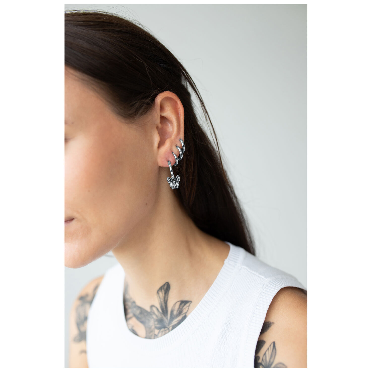 Boucles d'oreilles Little Bulldog argentées à l'oreille Femme portant des boucles d'oreilles Little Bulldog argentées avec fermoir à clip