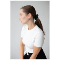 Little Soulmate Hoops à l'oreille d'une femme Femme en t-shirt blanc portant des Little Soulmate Hoops en argent devant un fond gris
