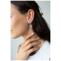 Créoles Mystic Snake argentées à l'oreille Boucles d'oreilles serpent argentées à l'oreille d'une femme sur fond clair