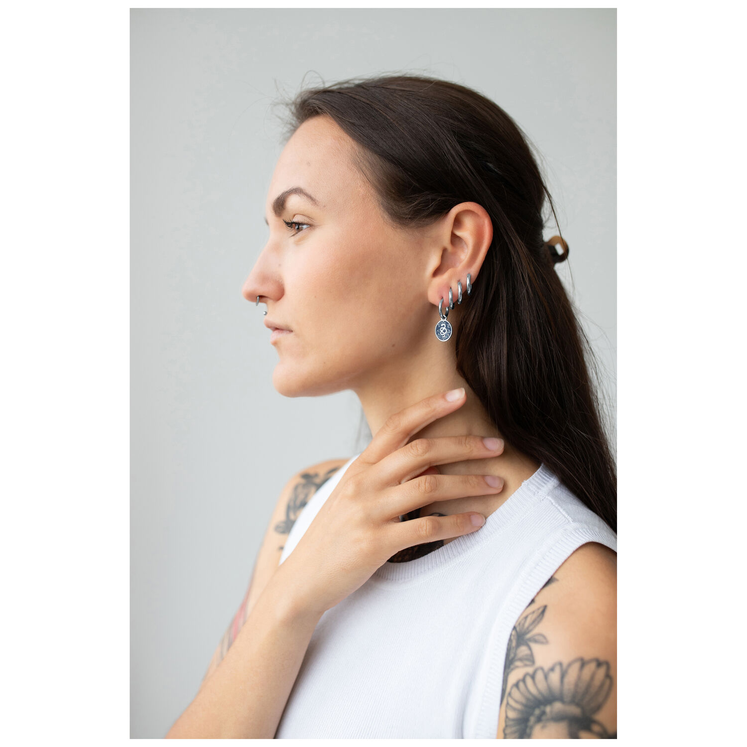 Créoles Mystic Snake argentées à l'oreille Femme avec créoles Mystic Snake argentées, profil latéral, haut blanc