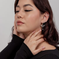Boucles d'oreilles libellule élégantes avec perle Femme avec plusieurs boucles d'oreilles, y compris une boucle d'oreille libellule avec perle, sur fond clair