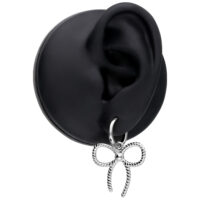 Boucles d'oreilles en acier inoxydable avec nœud Boucles d'oreilles argentées avec détail de nœud sur un modèle d'oreille noire