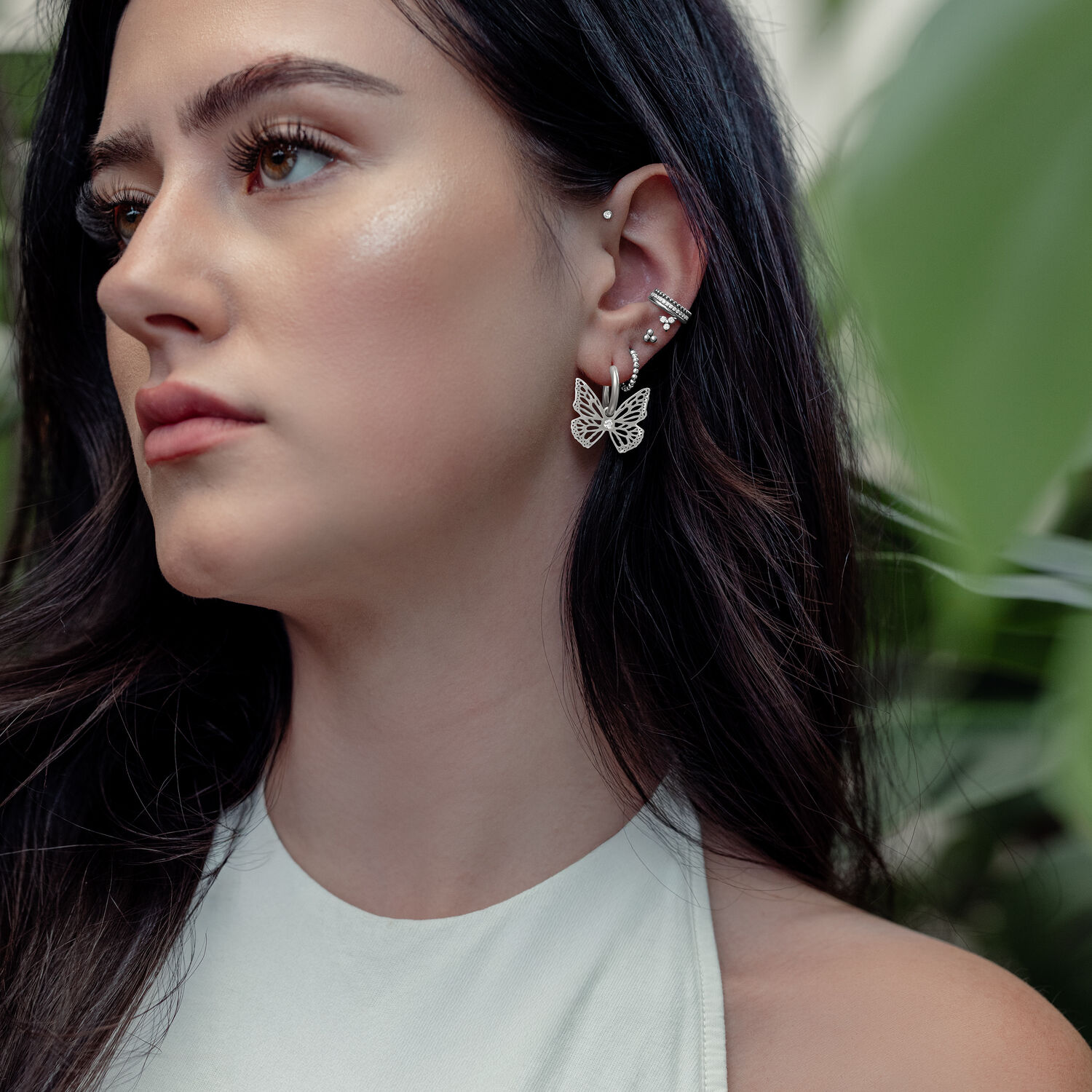 Boucles d'oreilles élégantes Little Butterfly en argent Femme avec des boucles d'oreilles papillon en argent, en extérieur, avec des plantes en arrière-plan