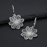 Boucles d'oreilles en acier inoxydable de haute qualité avec motif floral Boucles d'oreilles en acier inoxydable argentées avec design floral sur fond sombre