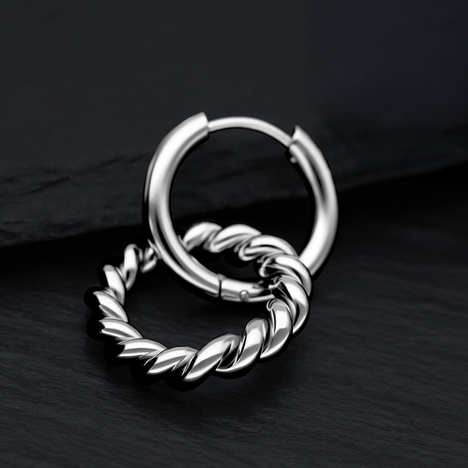 Boucles d'oreilles Twisted Circle en acier inoxydable sur fond noir