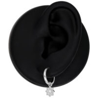 Boucles d'oreilles Mini Flower en argent sur modèle d'oreille noir, poli brillant