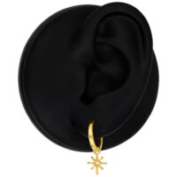 Mini Polar Star Hoops en or sur un modèle d'oreille noir devant un fond neutre