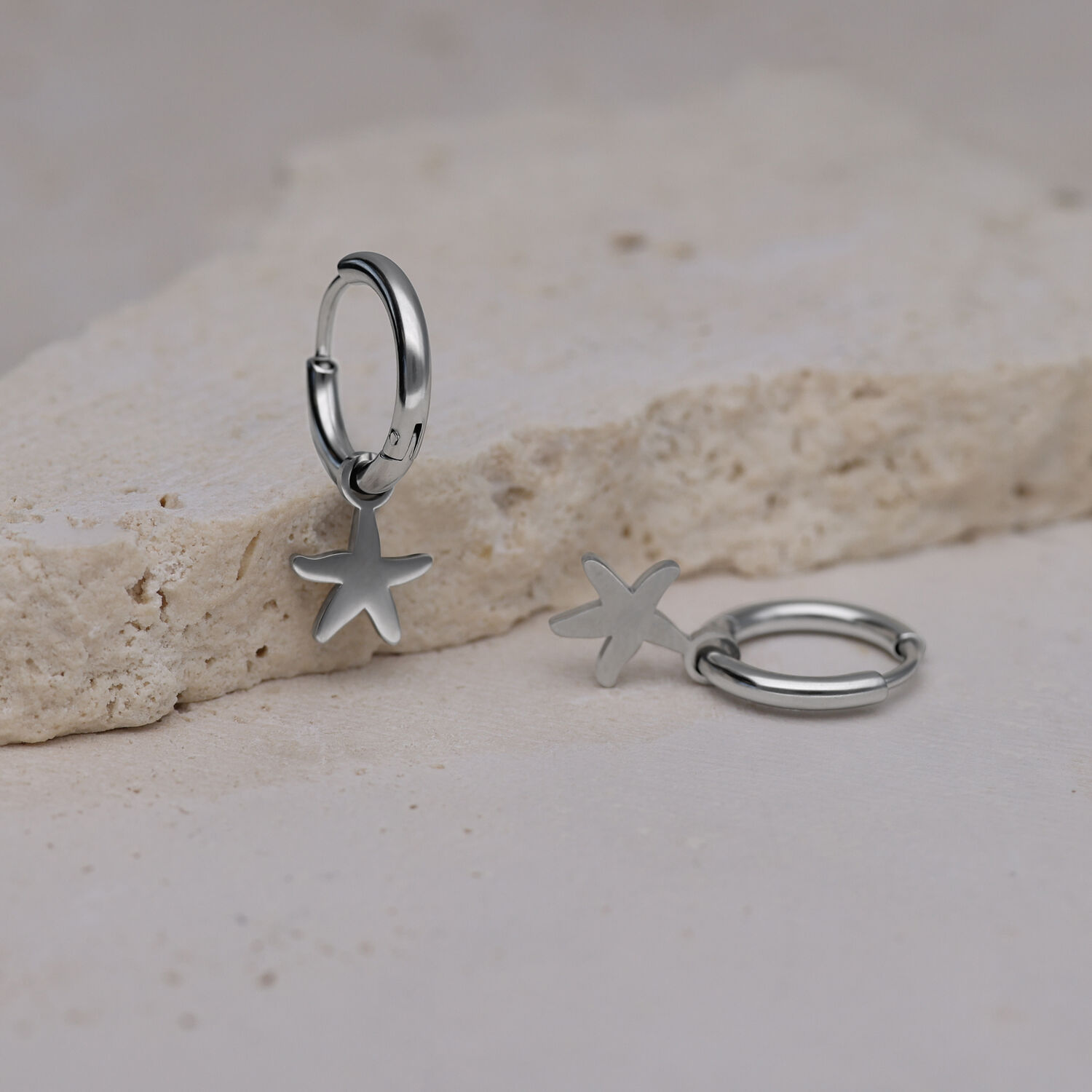 Deux créoles argentées avec pendentif étoile de mer sur pierre claire