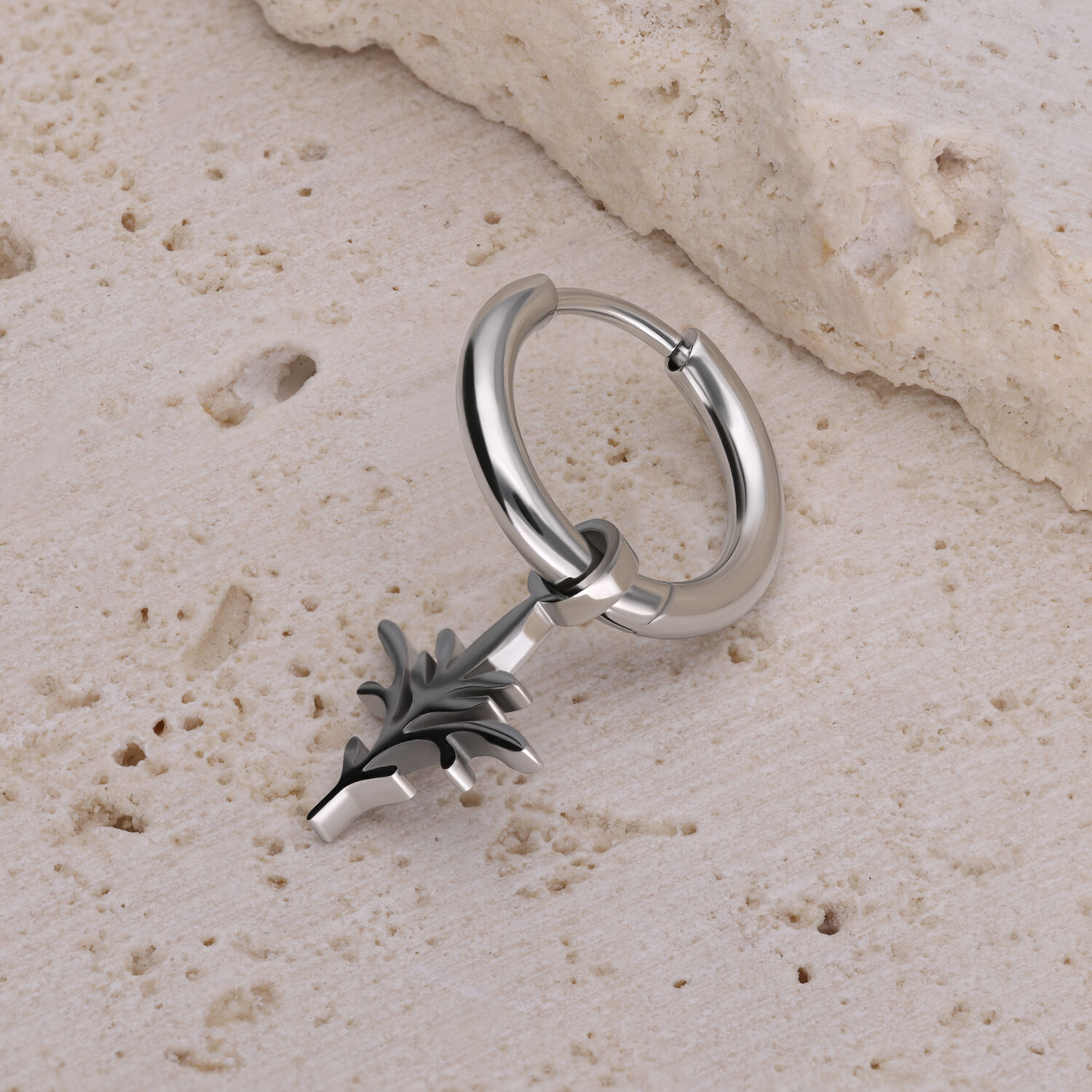 Boucle d'oreille en argent avec pendentif branche Boucle d'oreille créole en argent avec pendentif noir en forme de branche sur pierre claire
