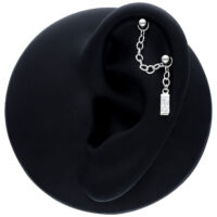 Chaîne de piercing pendante noire avec cristal baguette Chaîne de piercing noire avec cristal baguette pendante sur un modèle d'oreille