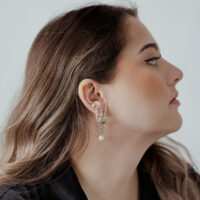 Chaîne de piercing élégante en argent à l'oreille Femme avec chaîne de piercing en argent à l'oreille, cheveux sur le côté, fond clair