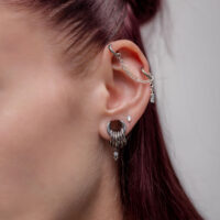 Chaîne de piercing en argent portée à l'oreille Oreille avec chaîne de piercing en argent et plusieurs piercings, vue latérale