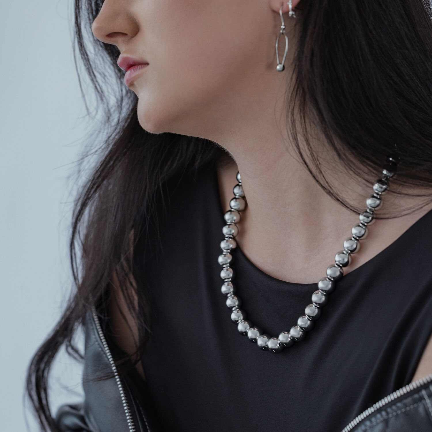 Collier Bulle en Argent en Acier Chirurgical Femme portant un collier bulle en argent en acier chirurgical avec un haut noir
