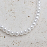 Grand collier de perles synthétiques en argent Collier de perles synthétiques argentées sur fond de pierre claire