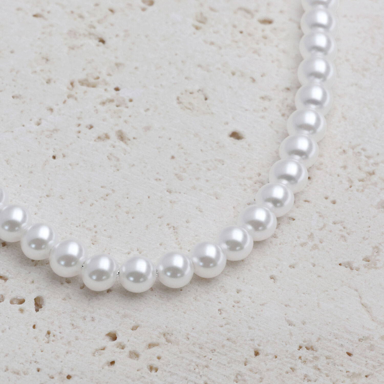 Grand collier de perles synthétiques en argent Collier de perles synthétiques argentées sur fond de pierre claire