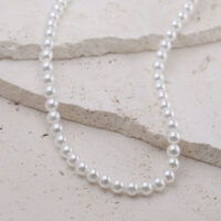 Grand collier de perles synthétiques en argent Collier de perles argentées en acier chirurgical sur fond clair