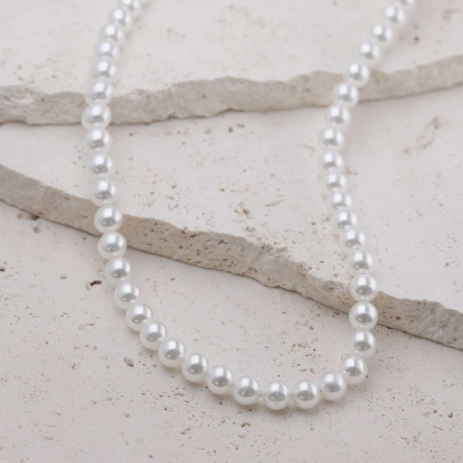 Grand collier de perles synthétiques en argent Collier de perles argentées en acier chirurgical sur fond clair