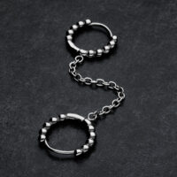 Double Huggie Ball Hoops en argent Double Huggie Ball Hoops en argent avec chaîne sur fond sombre