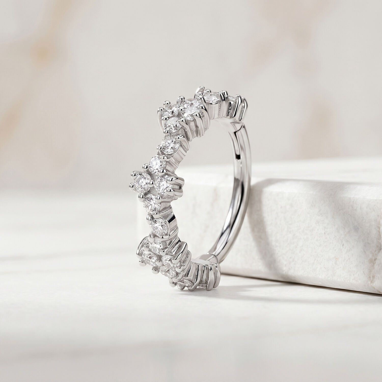 Clicker Tiara argenté avec cristaux Anneau de piercing argenté avec cristaux clairs sur fond de marbre blanc