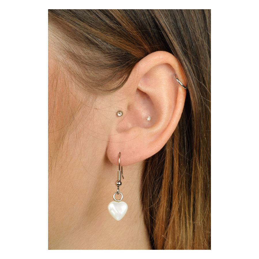 Boucles d'oreilles cœur blanches en argent pour femmes Boucles d'oreilles blanches en forme de cœur en argent sur une oreille avec des cheveux bruns