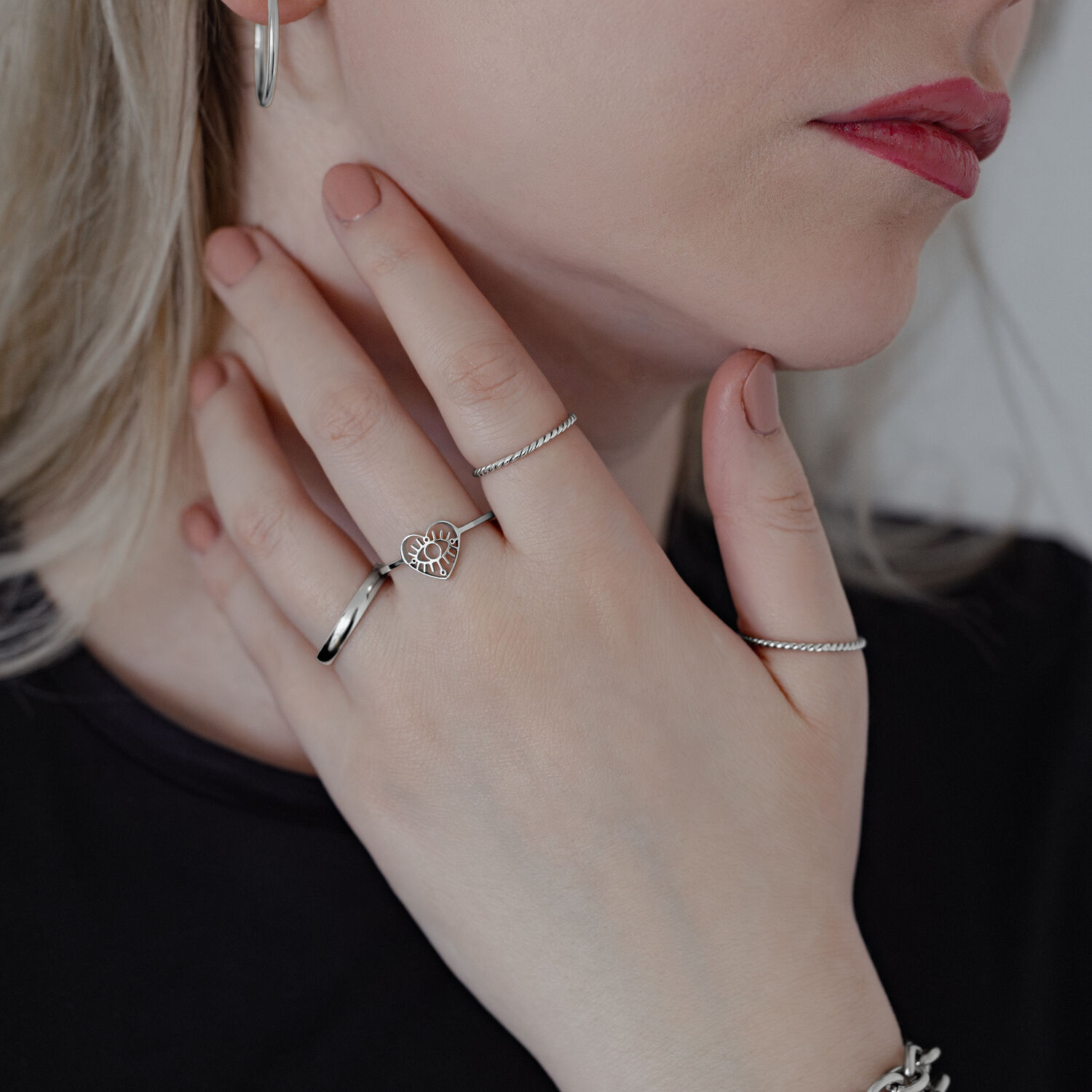 Élégant anneau Eye en acier chirurgical Femme portant plusieurs bagues, dont une bague Eye en argent sur fond clair