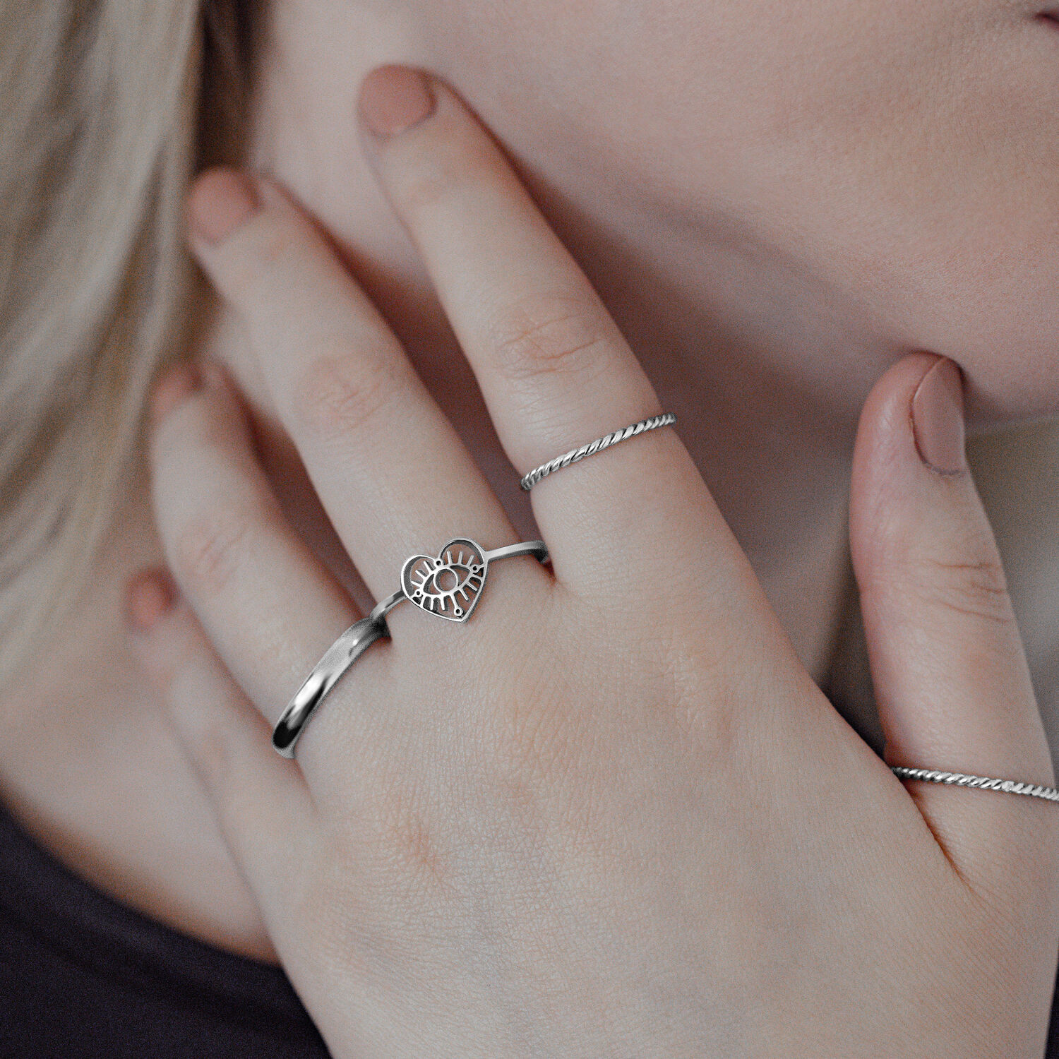 Bague Œil élégante en acier chirurgical Bague Œil en argent en acier chirurgical sur une main de femme, design cœur, gros plan