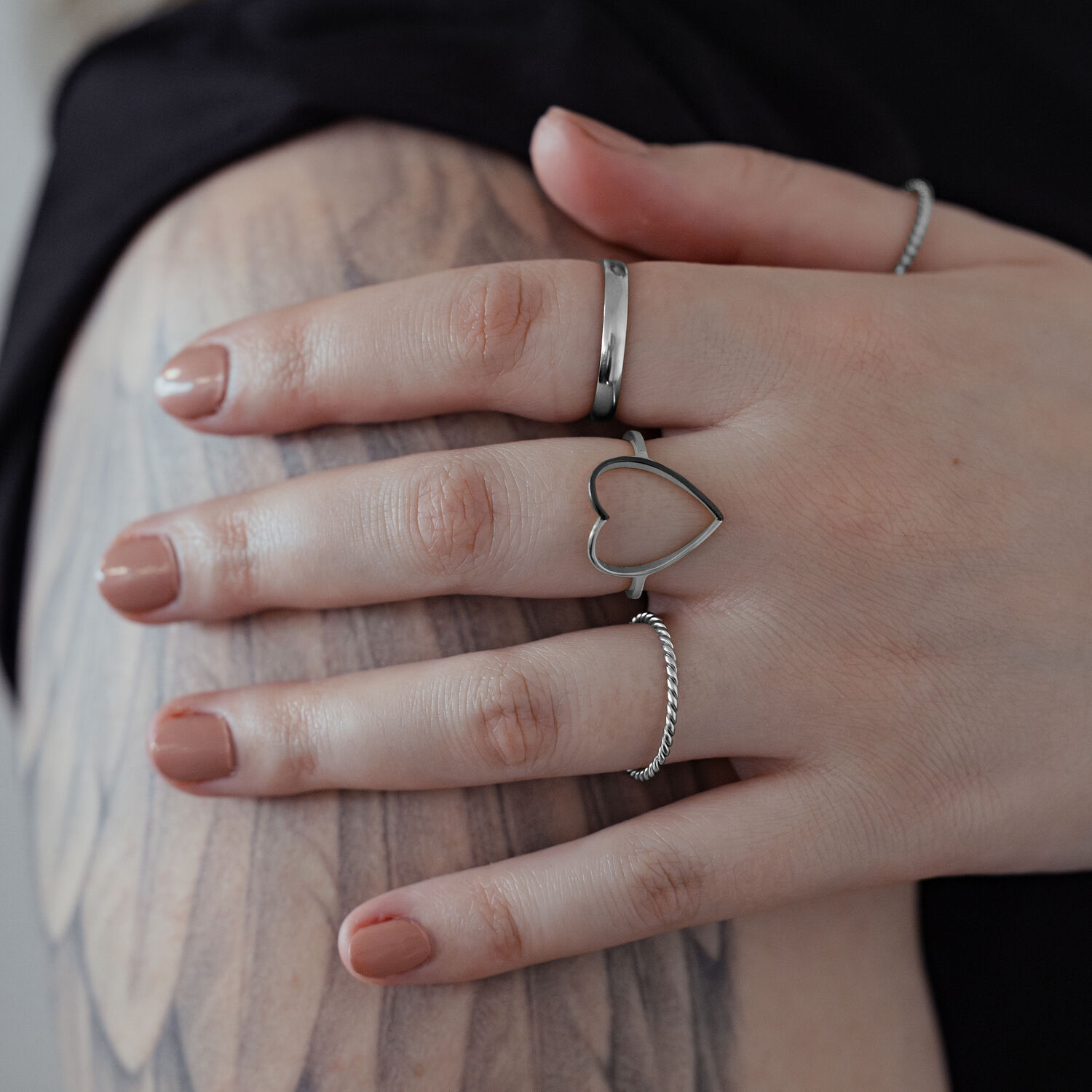 Bague cœur bicolore en acier chirurgical Bague cœur en argent en acier chirurgical sur une main avec bras tatoué