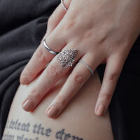 Bague Lovely Leaf en argent sur main Bague en argent au design de feuille sur une main féminine sur fond noir