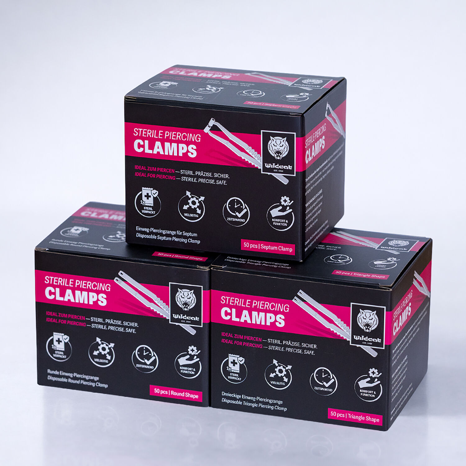 Trois boîtes noires avec l'inscription 'Sterile Piercing Clamps' sur fond blanc