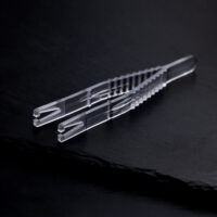 Pince à piercing triangulaire stérile sur fond noir Pince à piercing triangulaire stérile claire sur fond noir, emballée individuellement