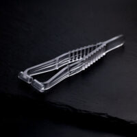 Pince à septum stérile sur fond noir Pince à septum transparente en plastique sur fond sombre et lisse