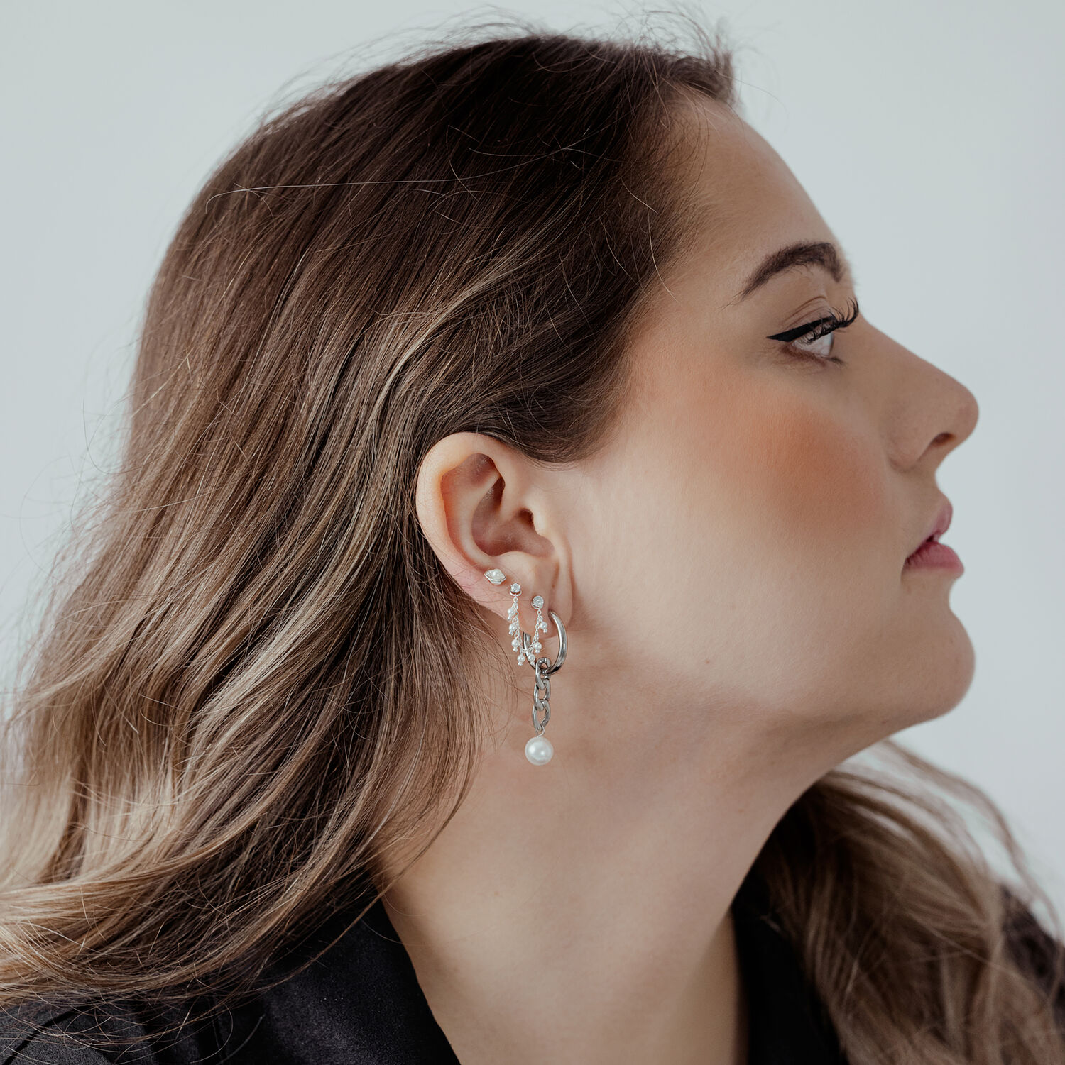 Élégant embout Push Fit en argent Femme avec embout Push Fit en argent à l'oreille, de profil sur fond blanc