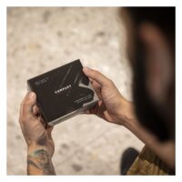 Alimentation Piranha noire en boîte Homme tenant une boîte d'alimentation Piranha noire avec un tatouage sur la main