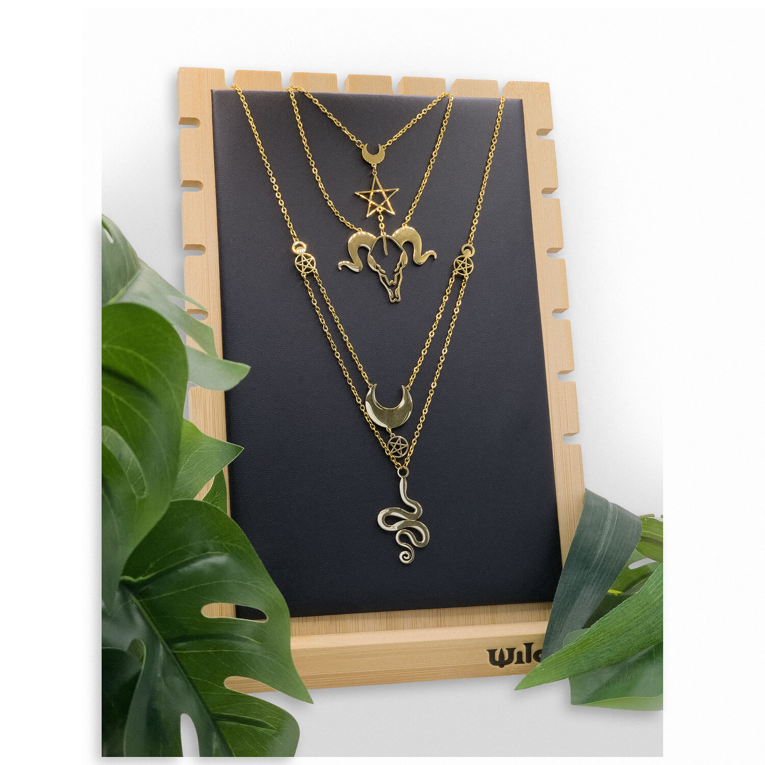 Présentoir à bijoux noir de Wildcat Présentoir à colliers noir de Wildcat avec des chaînes dorées, sur cadre en bois.