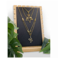 Présentoir à bijoux noir pour colliers Présentoir noir avec trois colliers dorés sur cadre en bois