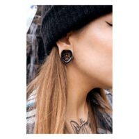 Gros plan d'une personne portant une selle d'oreille noire avec pentagramme, portée à l'oreille, en extérieur