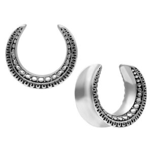 Deux Ear Saddles argentés avec motif Maori sur fond blanc
